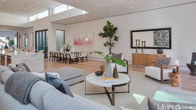 living room featuring a high ceiling and light hardwood / wood-style flooring