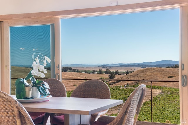 dining space featuring a healthy amount of sunlight, a mountain view, and a rural view