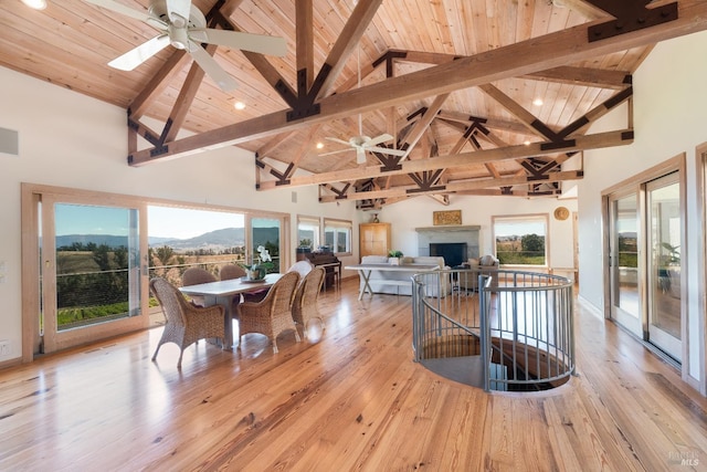 dining space with light hardwood / wood-style floors, wood ceiling, and high vaulted ceiling