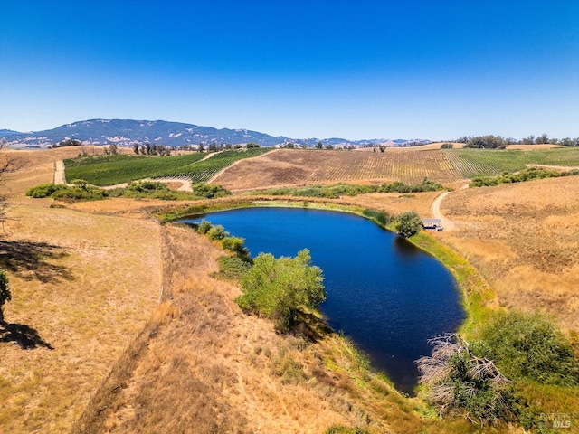 drone / aerial view featuring a water and mountain view and a rural view