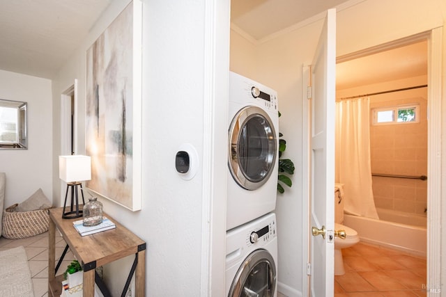 laundry area featuring light tile patterned floors, stacked washer and clothes dryer, and ornamental molding