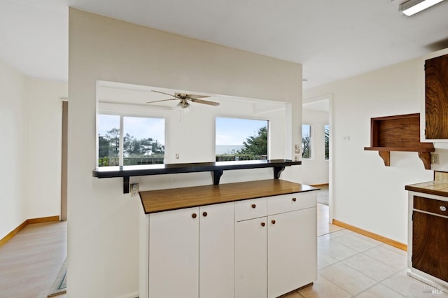 kitchen featuring white cabinets, ceiling fan, and light hardwood / wood-style flooring