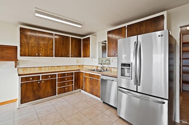 kitchen featuring light tile patterned floors, stainless steel appliances, and sink