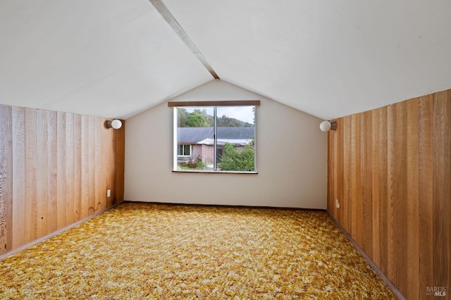 bonus room with lofted ceiling, wood walls, and carpet floors