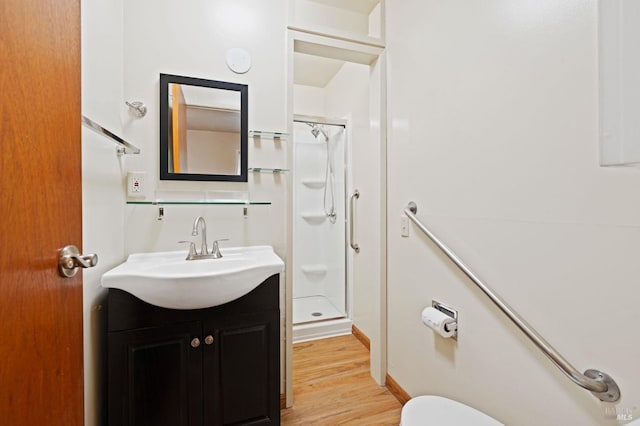 bathroom featuring vanity, toilet, wood-type flooring, and walk in shower