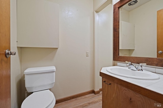 bathroom with vanity, toilet, and wood-type flooring