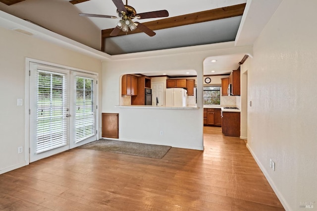 unfurnished living room with vaulted ceiling, ceiling fan, and light hardwood / wood-style floors