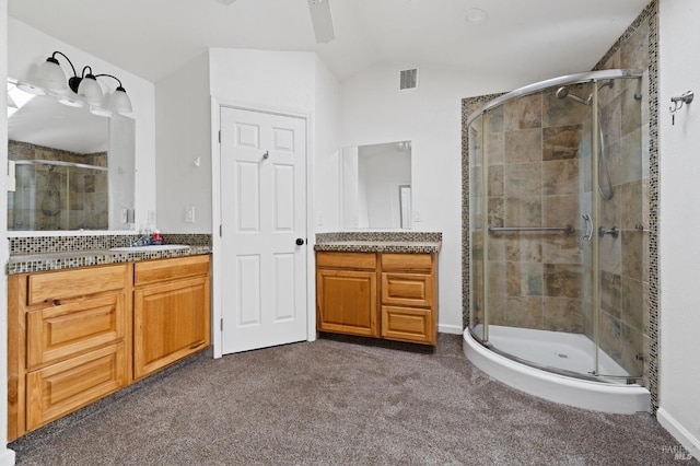 bathroom featuring a shower with door, vanity, ceiling fan, and vaulted ceiling