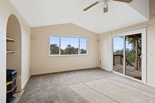 interior space featuring lofted ceiling, ceiling fan, light carpet, and a healthy amount of sunlight