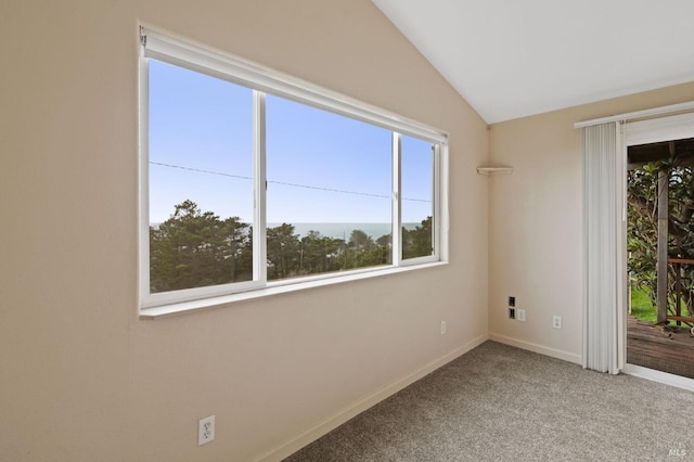 carpeted spare room featuring vaulted ceiling and a water view