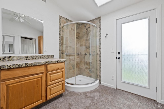 bathroom featuring lofted ceiling, walk in shower, ceiling fan, and vanity