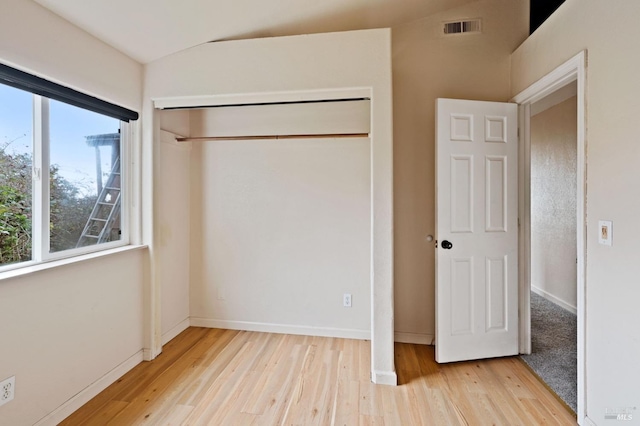 unfurnished bedroom with light wood-type flooring and a closet