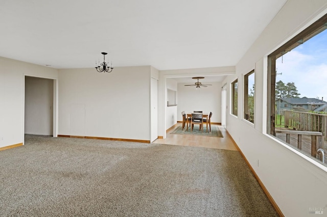 empty room featuring light hardwood / wood-style flooring and ceiling fan with notable chandelier