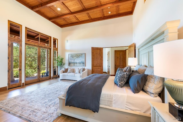 bedroom with wooden ceiling, french doors, a high ceiling, and light wood-type flooring