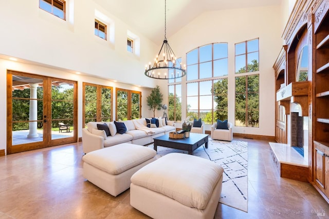 living room featuring plenty of natural light, high vaulted ceiling, french doors, and a chandelier