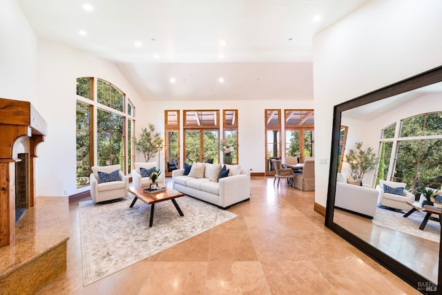 living room with a high end fireplace and high vaulted ceiling