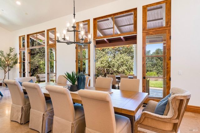 dining room featuring an inviting chandelier, lofted ceiling, and french doors