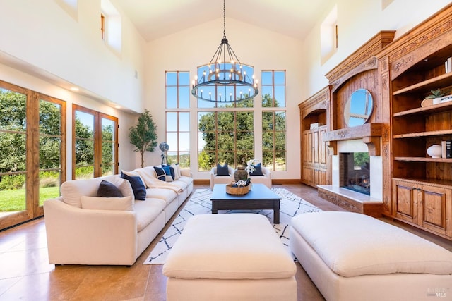 living room with built in shelves, a chandelier, and high vaulted ceiling