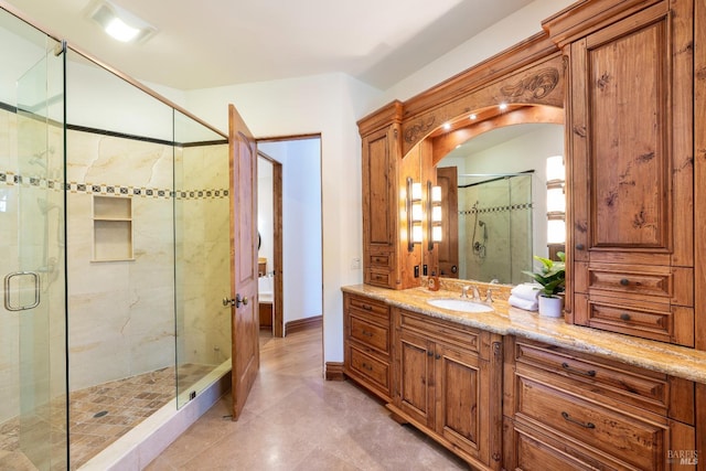 bathroom with tile patterned flooring, vanity, and walk in shower