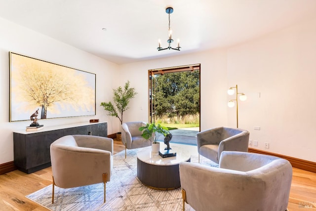 living area with an inviting chandelier and light hardwood / wood-style floors