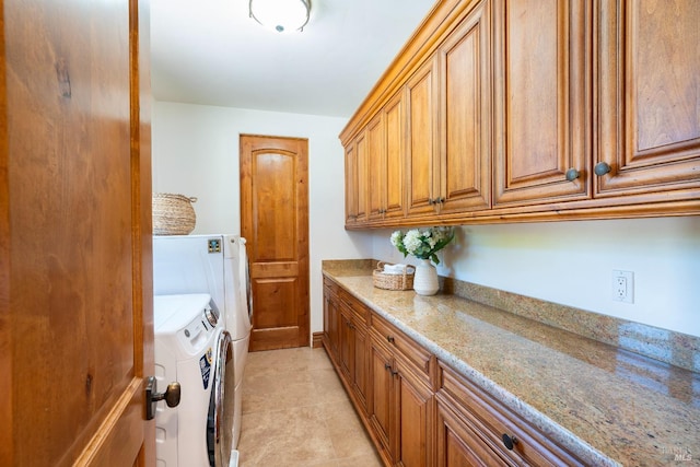 washroom with cabinets, washing machine and clothes dryer, and light tile patterned flooring