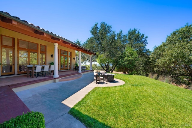 view of yard featuring a fire pit and a patio