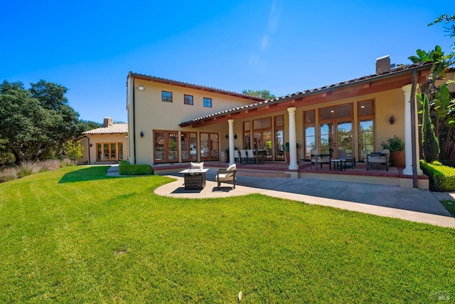 rear view of property with french doors, a yard, and a patio