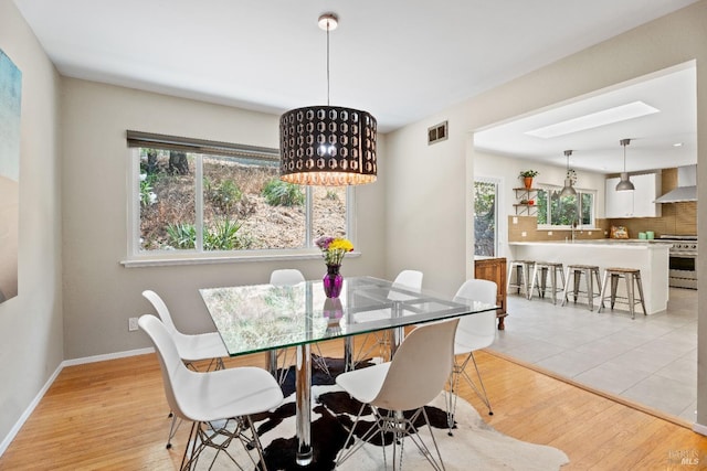 dining area with light wood-type flooring and sink