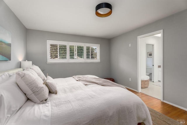 bedroom featuring connected bathroom and hardwood / wood-style floors