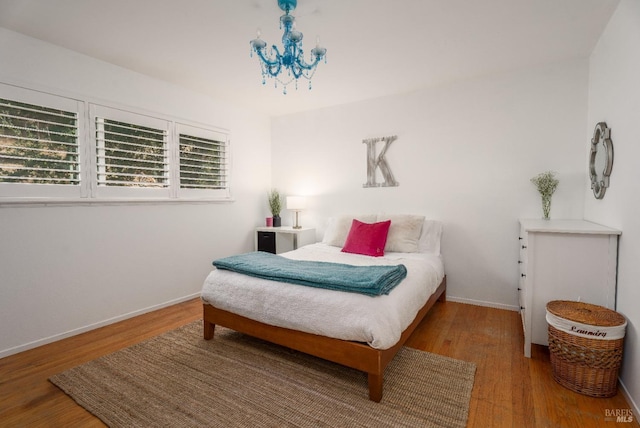 bedroom with a notable chandelier and hardwood / wood-style floors