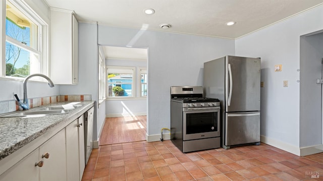 kitchen with light hardwood / wood-style floors, fridge, a healthy amount of sunlight, and stove