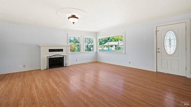 unfurnished living room featuring crown molding and light hardwood / wood-style flooring