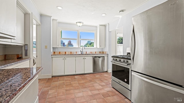 kitchen with dishwasher, white cabinetry, refrigerator, stove, and light tile patterned flooring