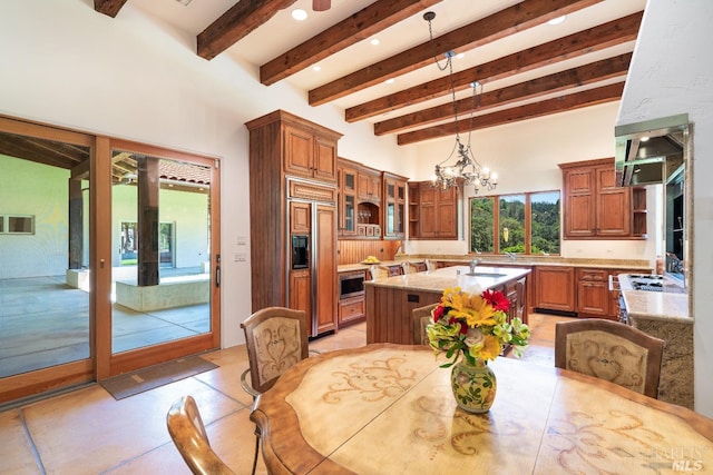 dining space with sink, a notable chandelier, light tile patterned floors, and beamed ceiling