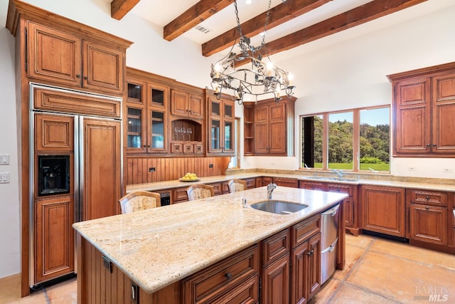 kitchen with fridge, pendant lighting, an island with sink, sink, and light tile patterned flooring