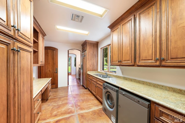 kitchen featuring sink, light tile patterned flooring, dishwasher, and light stone countertops