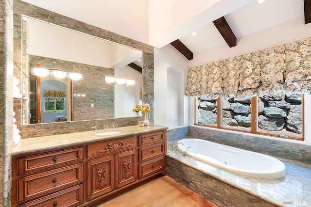 bathroom featuring vaulted ceiling with beams, vanity, and tiled tub