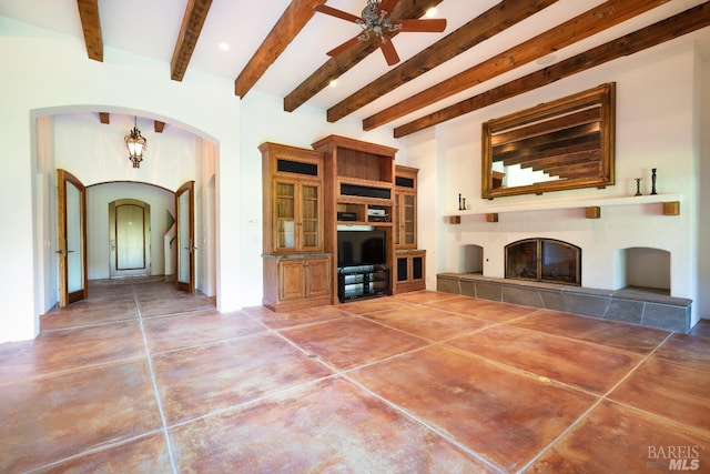 unfurnished living room with a fireplace, beam ceiling, built in shelves, and ceiling fan