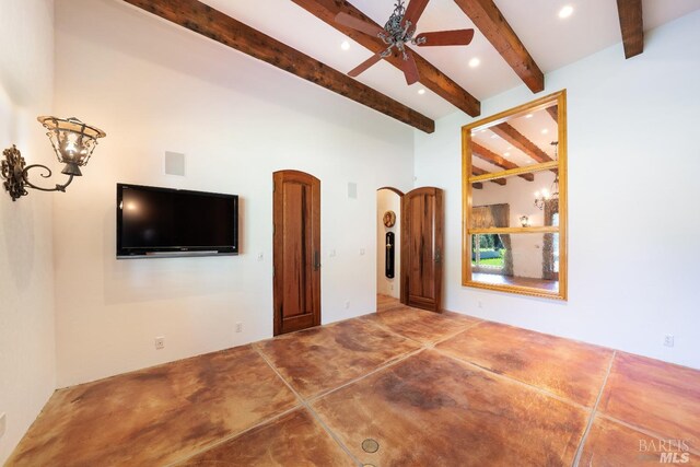 unfurnished living room featuring ceiling fan and beamed ceiling