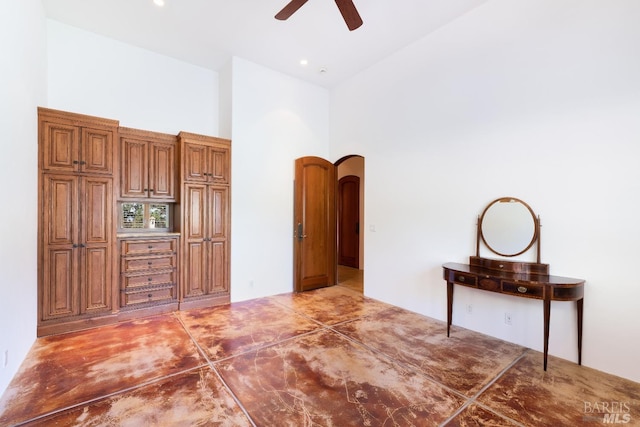 interior space featuring ceiling fan and a high ceiling