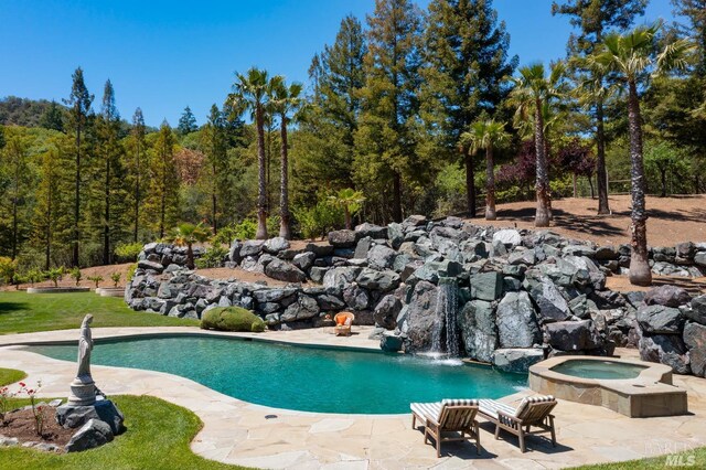 view of pool with an in ground hot tub