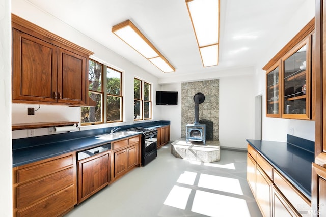 kitchen featuring sink, range with gas stovetop, and a wood stove