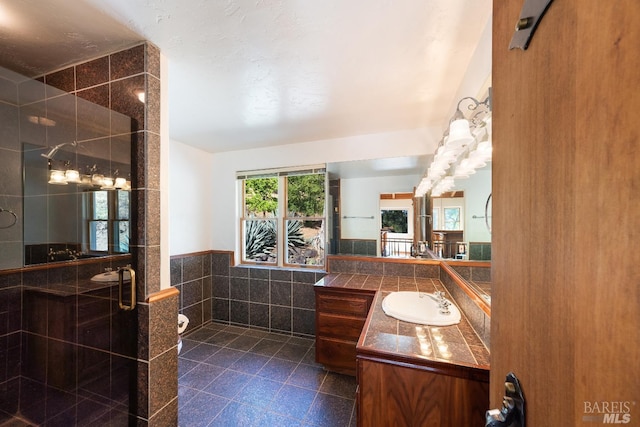 bathroom featuring a shower with shower door, tile patterned flooring, and vanity