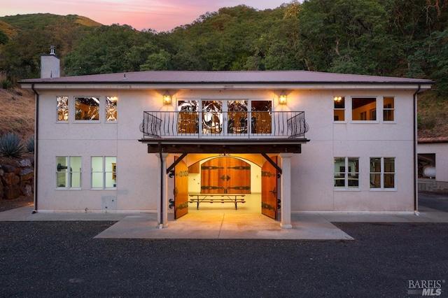 view of front of home with a balcony and a patio area