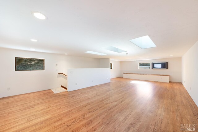 bonus room featuring light hardwood / wood-style floors and a skylight