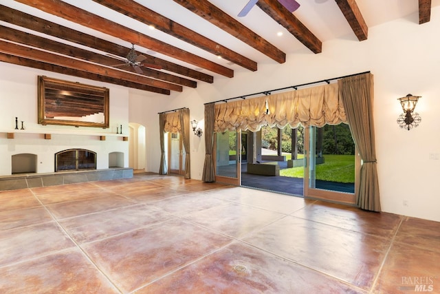 unfurnished living room featuring a fireplace, ceiling fan, and beamed ceiling