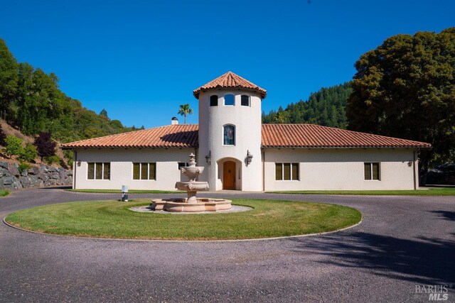 mediterranean / spanish-style house with a front yard