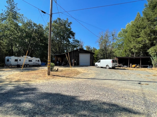 view of yard featuring an outbuilding, driveway, and a detached garage