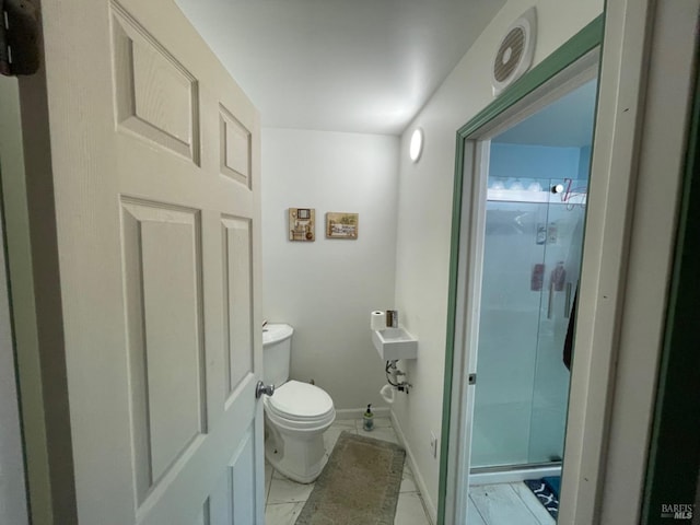 full bathroom with a stall shower, marble finish floor, baseboards, and toilet