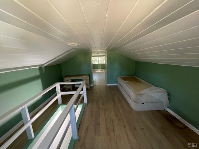 additional living space with baseboards, vaulted ceiling, and wood finished floors